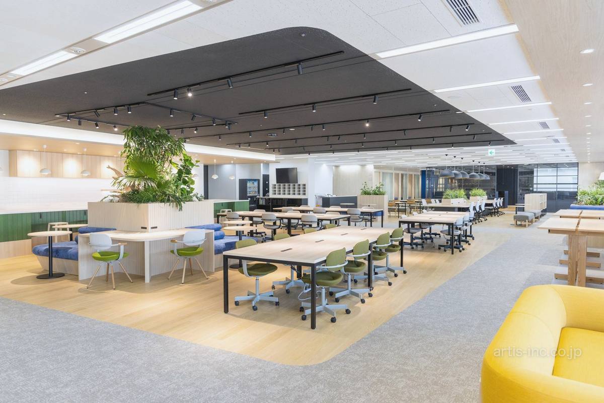 植栽のある島と大きなテーブルが並ぶ、見通しのよい執務エリア